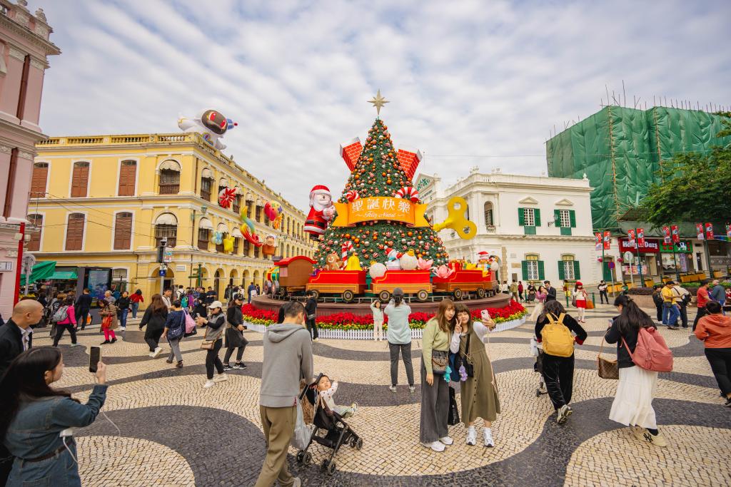 12月12日,游客在澳门议事亭前地的圣诞树前拍照。新华社记者 朱炜 摄