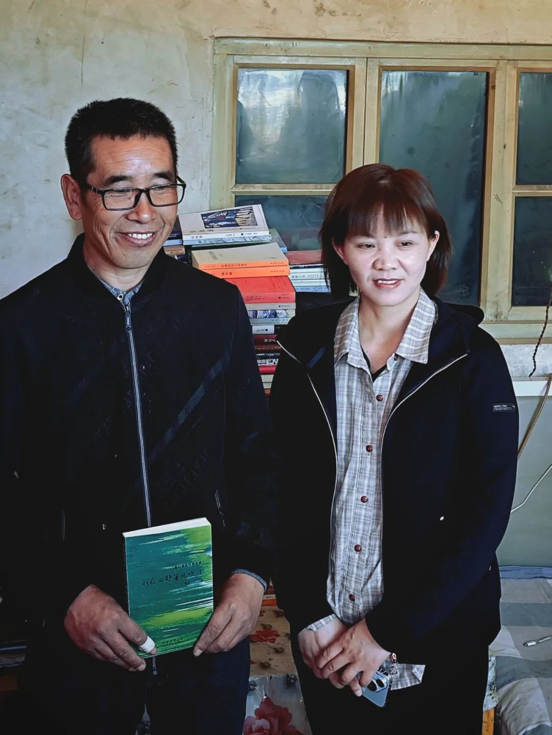 曹兵捧着自己的诗集与贺秋菊合影留念